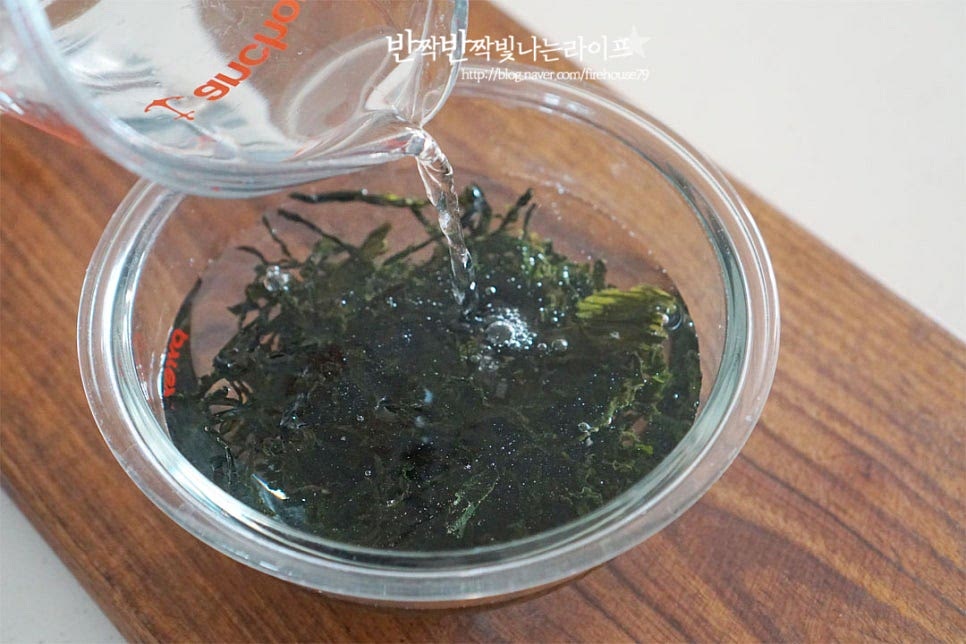 자른 건미역을 준비했어요. 가볍게 한두 번 헹구어 겉의 이물질을 털어낸 뒤 큰 볼에 물을 넉넉하게 부어 불려줍니다. 불리기 전에는 양이 적은 것 같아도 불리면 꽤 양이 많아집니다. 물을 붓고 15분 충분히 불려준 뒤 다시 한번 가볍게 헹구어 물기를 꼭 짜줍니다. 자연산은 이물질이 많이 묻어나므로 더 꼼꼼하게 세척해 줍니다. 자른 것은 그대로 국에 넣어주고, 길이에 따라 한 입 크기로 잘라줍니다.