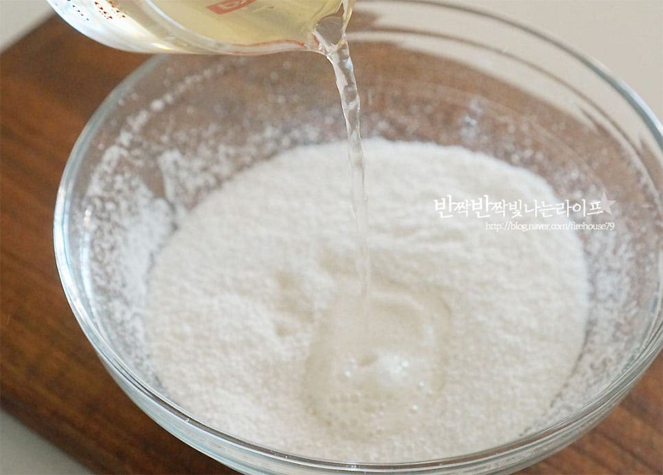 가루에 넣어가며 반죽 농도를 맞추어 줍니다. 시루에 쪄서 만드는 것은 가루가 뭉쳐질 정도로 수분을 조절해 주시면 되지만 전자레인지로 만들 땐 물을 넉넉히 넣어주시는 게 좋아요. 대략 뜨거운 물 120ml를 부어주었어요. 가루의 수분 정도에 따라 물을 조절해 주시고 걸쭉하게 묽은 정도로 반죽해 주세요. 날가루가 보이지 않게 섞어졌다면 랩을 씌워줍니다. 전자레인지 3분 정도 돌려주어요. 반죽이 찰지게 돌게 잘 섞어줍니다. 1분 정도 찰지게 반죽을 섞어주었어요.