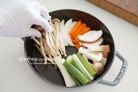 냄비 테두리로 재료를 빙 둘러 담아줍니다. 버섯과 야채를 번갈아가며 푸짐하게 올려주세요. 당면도 함께 올려줍니다. 가운데 양념한 소고기도 동그랗게 올려줍니다. 양념 국물도 부어주면 됩니다. 재료가 잘 보일 수 있도록 담으면 푸짐하고 맛있어 보인답니다. 육수도 자작하게 부어줍니다. 국물을 좋아한다면 조금 더 넉넉하게 부어도 좋습니다.