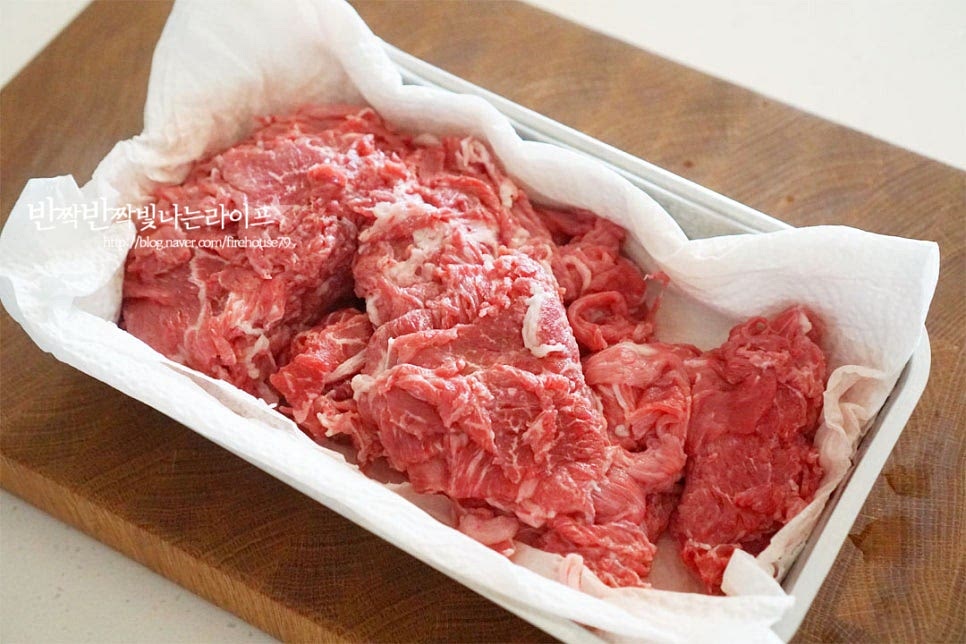 얇게 썬 소고기 불고깃감을 준비했어요. 크기에 따라 먹기 좋게 자르고 핏물을 제거해 줍니다. 핏물을 꼼꼼하게 제거해 주셔야 누린내 없이 깔끔하게 맛을 낼 수 있어요. 넉넉한 크기의 볼에 양념 재료를 넣어줍니다. 황설탕 1½ 큰 술, 진간장 4 큰 술 맛술 2 큰 술, 간 마늘 1 큰 술 생강가루 반 고집, 다진 대 파 2 큰 술 참기름 1/2 큰 술, 후추 약간 배즙 120ml, 간양파 1 큰 술을 넣어주세요. 배를 강판에 갈아서 체에 밭쳐 즙만 걸러주고 양파도 갈아서 넣었어요. 은은한 단맛과 부드러운 맛을 내어주는데요. 시판용 배주스를 넣어도 좋습니다. 단맛에 따라 너무 달지 않도록 설탕량을 조절해 주면 됩니다. 육수를 부어 끓여줄 것이라 단짠 양념을 약간 간간한 정도로 만들었습니다. 손질한 소고기를 넣고 조물조물 재워줍니다. 다른 재료를 손질하는 동안 재워주세요.