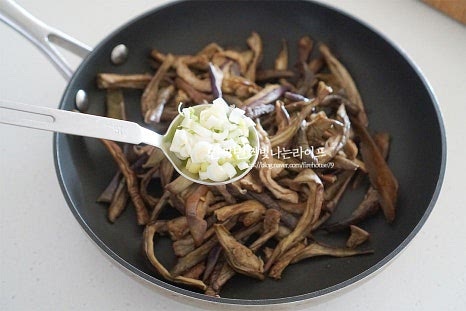 묵나물 같은 경우 간이 잘 밸 수 있도록 밑간을 해준 뒤 볶으면 맛이 풍부합니다. 깊은 팬에 재료를 넣고 다진 파 2 큰 술, 간 마늘 1/3 큰 술 국간장 2/3 큰 술, 어간장(액젓) 1/3 큰 술 맛술 1/2 큰 술, 들기름 2/3 큰 술 황설탕 두 꼬집을 넣어줍니다. 국간장과 어간장을 같이 넣고 감칠맛을 더욱 풍성하게 해주었는데요. 입맛에 따라 국간장만 넣어도 좋고 액젓을 약간 섞어서 넣어도 좋습니다. 황설탕을 약간 넣으면 묵나물 특유의 군내, 쓴맛을 잡아주는 역할을 해요. 단맛을 내기보다 잡내를 잡기 위해 넣기 때문에 너무 많이 넣을 필요는 없습니다. 간이 스며들 수 있도록 조물조물 버무려줍니다. 말린 나물이다 보니 조금 힘을 주어 버무리면 양념이 더 잘 뱁니다. 식용유 1 큰 술을 같이 넣고 볶음 준비를 해요.