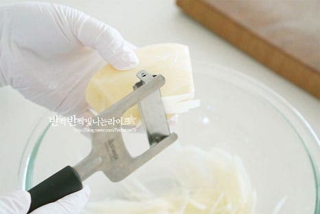 껍질을 제거한 뒤 일정한 두께로 채를 썰어줍니다. 이때 채칼을 사용하면 일정하게 채썰기 편합니다. 곱게 채썰어주셔야 바삭한 식감으로 전을 부칠 수 있으니 일정하고 곱게 잘라줍니다.