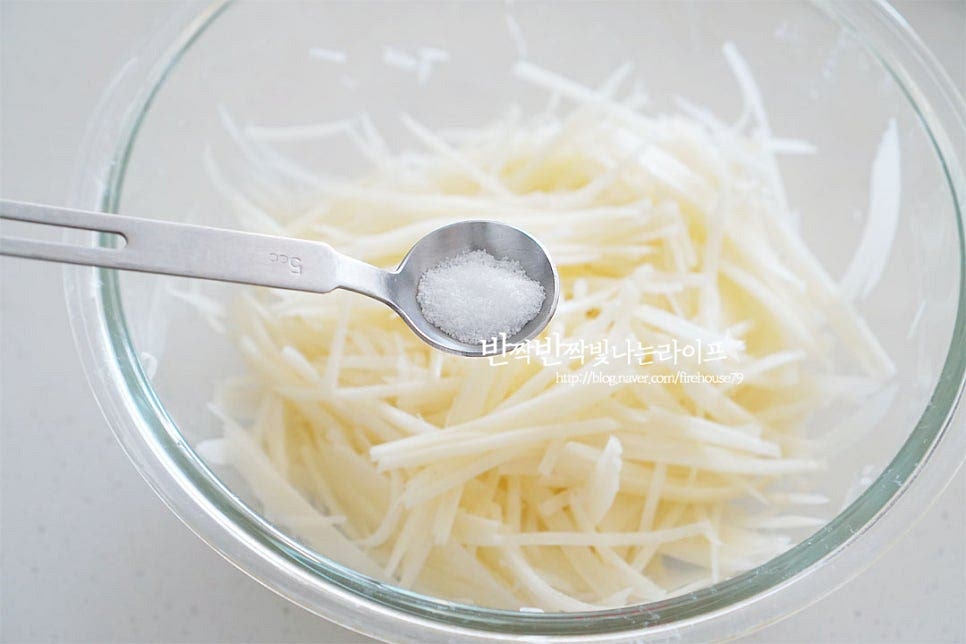 넉넉한 크기의 볼에 재료를 넣고 소금 2/3 작은 술을 골고루 뿌려 버무립니다. 전분가루를 더해 구워서 만들기도 하지만 재료 본연의 고소한 맛을 살리기 위해 소금에 절여 가루종류를 넣지 않고 만들기 할 것입니다. 부재료로 베이컨을 넣을 때는 간이 짜지 않도록 소금양은 줄여주는 게 좋습니다. 소금이 뭉치지 않도록 잘 섞어준 뒤 10분 정도 절입니다. 중간에 한두 번 뒤적여 10분 절이니 수분이 생기고 간이 스며들었습니다. 물기는 꼭 짜서 제거해 줍니다. 물기가 많으면 뭉쳐지지 않고 풀어져서 모양내기 어려우니 꼭 짜줍니다. 절여서 수분을 제거한 뒤 감자전 반죽을 만들면 재료의 맛도 진하고 바삭바삭합니다.