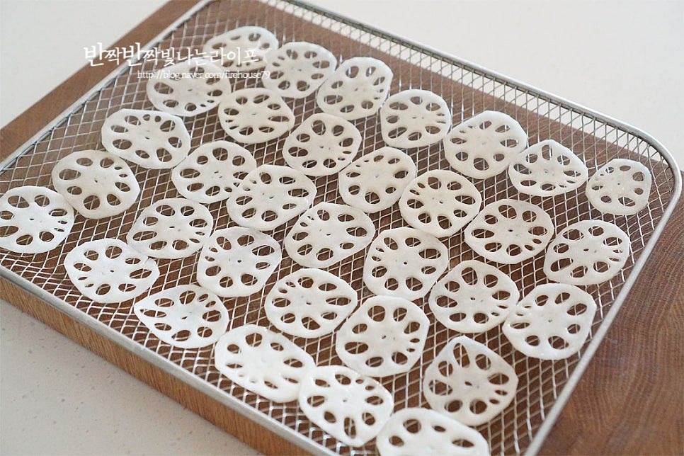 예열한 기름에 넣고 연근튀김을 만드는 방법보다 오늘은 기름을 소량만 사용하여 에어프라이어로 담백 고소하게 만들었습니다. 트레이에 겹치지 않게 올려줍니다. 얇게 썬 것이라 조리도중 뜨거운 바람에 날아기지않도록 두 개를 마주 보게 겹쳐서 에프에 넣어주었습니다. 에어프라이어 간식 연근칩은 160도 7~10분 정도 조리해줍니다. 재료의 두께나 양, 기기의 사양에 따라 온도와 시간은 조절해주세요. 중간에 익어가는 정도를 보고 시간을 맞춰 원하는 식감으로 튀겨주면 됩니다. 오븐형이라 따로 뒤집지 않고 구웠는데 중간에 앞뒤로 뒤집어 구워주면 바삭하게 맛볼 수 있어요. 노릇한 식감으로 구워지면 눅눅하지 않게 튀김망에 올려 한 김 식혀주세요.