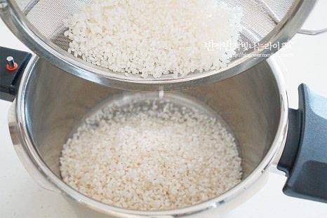 불린 쌀을 압력밥솥에 넣어줍니다. 밥물 기본 비율은 불리기 전 쌀 기준으로 쌀 1 : 물 1입니다. 잡곡밥을 할 때는 물의 양을 1.2 정도로 늘려주고 묵은쌀이나 불리지 않은 쌀도 조절이 필요하며 햅쌀은 조금 적게 잡아주셔도 되고요. 손등을 위로 올라오는 정도로 물을 맞추기도 하고 사용하는 압력솥의 계랑을 활용하기도 하지만 정확하게 계량컵이 실패없이 편합니다.