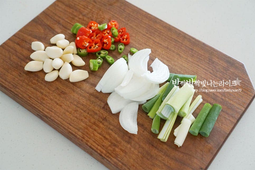 양파는 0.3cm 두께로 썰고, 대파, 청양고추도 같이 썰어줍니다. 마늘은 통으로 넣어줄 것인데요. 꼭지 부분을 잘라내고 크기가 큰 것은 반으로 잘라주세요. 매운맛 기호에 따라 고추를 넣어주시면 매콤하니 맛있습니다. 삼겹살은 대패, 냉동 상관없이 냉장고 사정에 따라 준비해요. 먹기 좋게 4cm 정도로 잘라주었습니다.