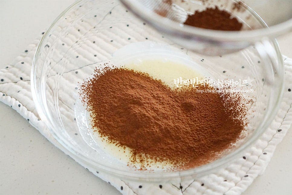 코코아파우더는 무가당으로 준비했습니다. 세 번에 나누어 넣고 반죽을 섞어줍니다. 가루가 골고루 어우러지게 나누어 넣어가며 반죽해 줍니다. 세 번에 나누어 넣어 날가루가 보이지 않고 한 덩어리가 되도록 해주어요. 한 덩어리로 뭉쳐지면 손으로 한 번 더 반죽해 줍니다. 납작하게 모양을 잡아준 뒤 랩으로 감싸 냉장실에 1시간 넣어둡니다.