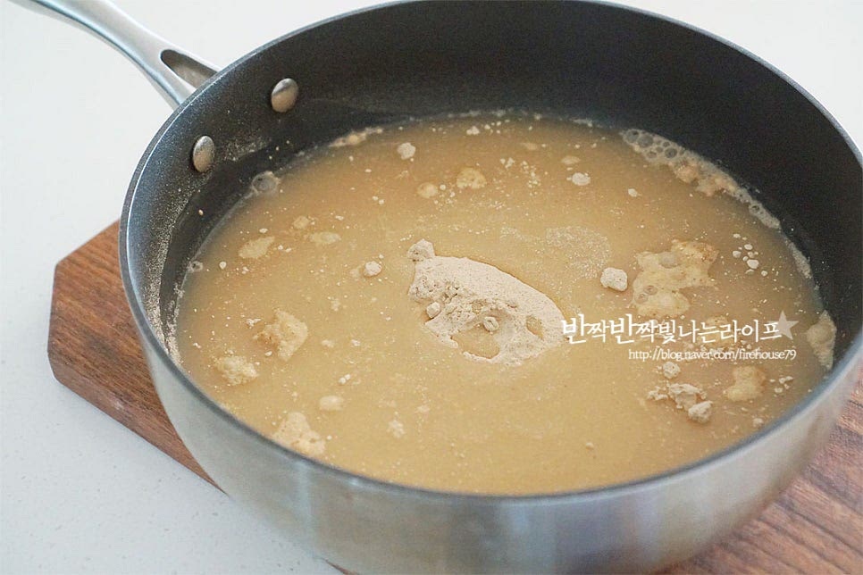 도토리묵은 가루와 물의 비율만 잘 맞추어주시면 탱글탱글한 농도로 만들기 어렵지 않아요. 도토리가루 1 : 물 6 비율로 저는 도토리 1컵에 물 6컵 부어주었습니다. 곱게 섞을 수 있도록 체에 한번 내려주었습니다. 날가루가 보이지 않도록 거품기로 잘 풀어 섞어줍니다. 섞은 뒤 바로 끓여도 되지만 찰기를 살려주기 위해 30분 정도 부어 불려주었습니다. 이 과정은 시간에 따라 생략 가능해요.