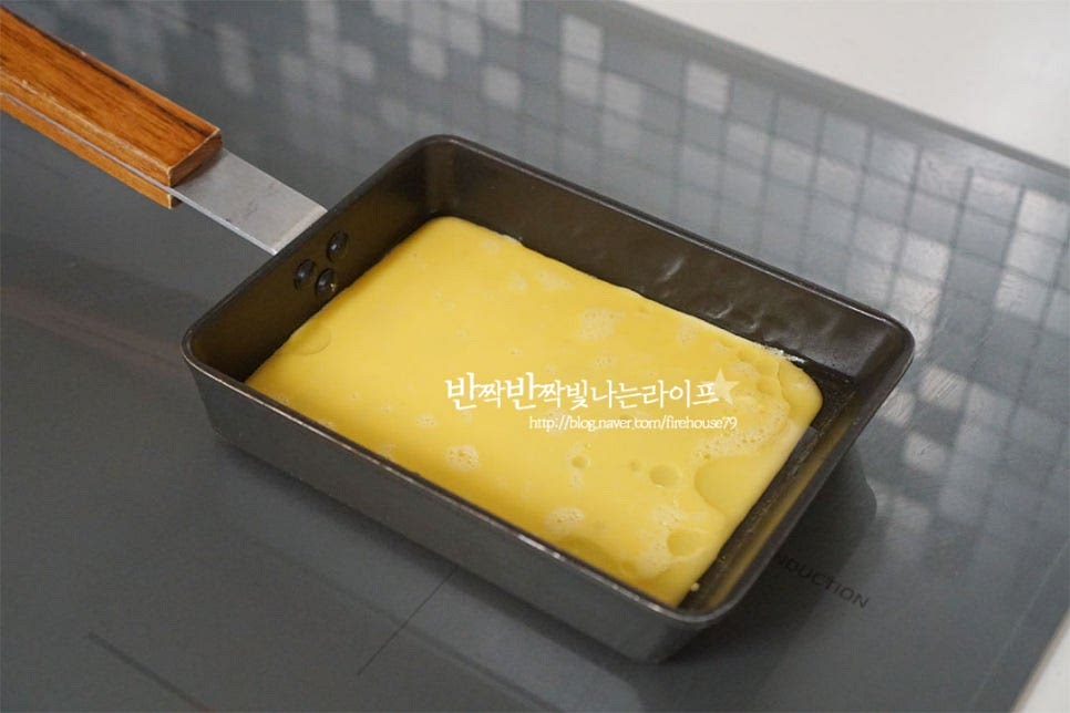 프라이팬을 달군 뒤 식용유를 약간 둘러줍니다. 그리고 풀어놓은 계란물을 얇게 부어주어요. 1/4 정도 익으면 그 위로 명란을 올려주어요. 한쪽 끝에 올려주고 접었을 때 덮어질 정도로 간격을 두고 올려주시면 되어요. 속에 꽉 차게 말아야 꽉차게 만들어진답니다. 반 이상 익어 색이 변한 게 보이면 돌돌 말아주기 시작합니다. 완숙으로 익히면 말아주는 과정에서 고정이 되지않아 촉촉한 반숙 상태일 때 모양을 잡아주셔야 고정이 되어요. 계속해서 달걀물을 얇게 부어가며 말아줍니다. 이음새 부분이 잘 붙어 연결되도록 팬을 비스듬히 눕혀 이음새 안쪽으로 넣어가며 말아주면 풀리지않고 같이 익어 더 먹음직스럽게 만들어져요. 위의 과정을 반복하여 모양을 잡아준 뒤 약불로 사면을 한 번 더 익혀 고정해 줍니다.