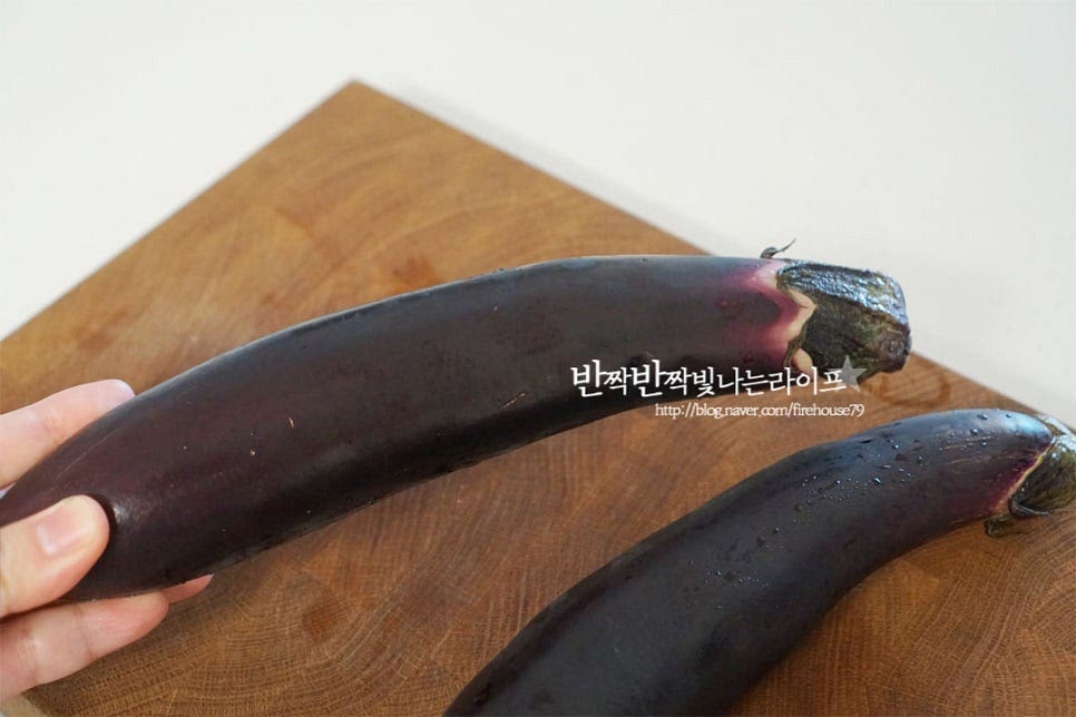 가지는 적당한 크기로 2개 준비했습니다. 색이 선명하고 너무 굵지 않아야 가운데 씨가 많지 않아 요리하기 좋습니다. 수분이 많은 재료라 바로 볶아 먹어야 물이 생지않고 식감이 더 맛있어요. 한번에 먹을만큼 만들어 드시는게 좋습니다. 표면을 문질러 깨끗하게 씻어줍니다. 물기를 제거한 뒤 꼭지 부분을 잘라내어 줍니다. 반으로 길게 자른 뒤 어슷하게 슬라이스해요. 자르는 방법은 여러가지가 있는데 일정한 두께로 썰어야 고르게 식감을 낼 수 있으며 너무 두꺼워도 간이 배지 않고 얇아도 물러져버립니다.