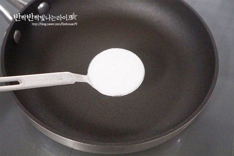 올리고당이나 꿀로 버무리기만 해도 되지만 바삭하게 손에 묻지 않는 시럽을 설탕으로 만들어줍니다. 팬에 설탕 3 큰 술, 식용유 1½ 큰 술을 넣어줍니다. 그대로 젓지 않고 중약불에서 녹여줍니다. 녹는 정도를 보아가며 타지 않게 약불에서 천천히 녹여줍니다. 도구를 사용해 억지로 저으면 굳어버릴 수 있으니 살짝 팬을 돌려주는 정도는 괜찮지만 젓지 말고 그대로 녹이면 됩니다. 점점 설탕이 녹으면서 약간 갈색빛이 윤기나게 만들어집니다. 시럽이 타지 않도록 약불에서 에프에 튀긴 고구마를 넣고 빠르게 버무립니다. 양손에 도구를 들고 빠르게 섞어주는 게 중요합니다. 시럽이 버무려지면 종이호일에 올려 설탕을 바삭 굳힙니다. 서로 붙지 않도록 하나씩 올려 열기를 식히면 손에 묻어나지 않고 굳습니다. 뜨거울 때 검은깨를 뿌리면 고소하게 완성할 수 있습니다. 저는 깜박하고 굳기 전에 빠르게 뿌렸어요.
