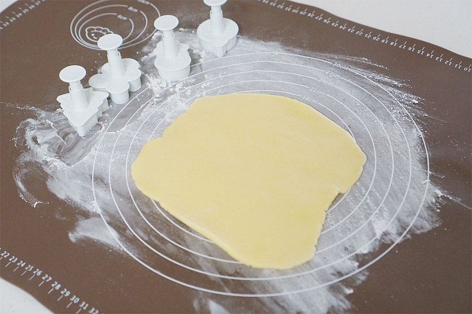 바닥면에 밀가루 약간 뿌린 뒤 반죽을 올려줍니다. 쿠키틀로 모양을 찍어줍니다. 차가운 상태로 모양을 내어주면 쿠키틀에 붙지 않고 깔끔하게 모양이 잡혀요. 모양틀을 찍고 남으면 다시 밀대로 두께를 밀어 또 찍어 모양을 내어줍니다.