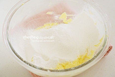 박력분 100g, 베이킹파우더 2g을 곱게 체에 내려준 뒤 주걱을 11자로 세워 가볍게 섞어줍니다. 대충 어우러지면 착즙해둔 레몬즙 13g을 넣고 주걱을 세워 반죽해 줍니다.