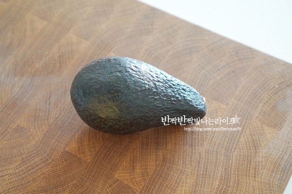 아보카도를 맛있게 먹기 위해서는 후숙이 되어야 합니다. 익지 않은 초록색의 단단한 열매는 풋내가 나고 단단하기 때문에 겉으로 보았을 때 껍질이 진한 갈색으로 부드럽게 눌러지는 정도면 비빔밥에 넣고 비벼 먹기에 좋습니다. 흐르는 물로 씻어 물기를 제거하고 가운데 씨를 중심으로 칼집을 넣어준 뒤 양쪽을 잡고 서로 반대 방향으로 비틀면 반으로 손쉽게 분리가 됩니다. 칼턱으로 고정한 뒤 가볍게 돌려주면서 가운데 씨를 분리하여 제거하고, 껍질도 벗겨줍니다. 잘 후숙된 상태로 껍질을 약간 뜯으면 모양 따라 쉽게 벗겨집니다. 익어서 무른 상태이므로 뭉개지지 않도록 조심하여 손질해 주세요. 씨와 껍질을 제거했다면 일정한 크기로 잘라줍니다. 모양대로 잘라주거나 한입에 먹기 좋게 깍둑썰기해주셔도 좋습니다.