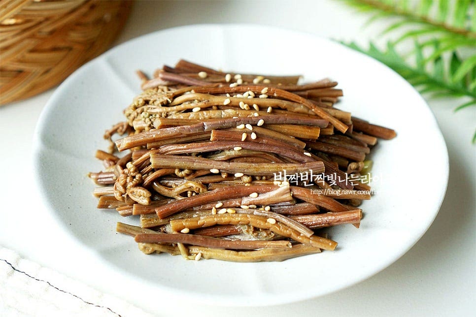 완성된 요리는 접시에 푸짐하게 올려 담은 뒤 통깨를 약간 뿌려줍니다. 고사리 풍미를 깔끔하게 맛을 내기 위해 마지막에 통깨를 넣고 볶음을 마무리했는데요. 입맛에 따라 들깨가루를 넣어도 좋습니다. 영상도 같이 담았어요. 삶은 고사리로 볶음 반찬 만들어 먹으면 데치는 조리과정 없이 간단하게 요리할 수 있으며 볶음 만들기 전 밑간한 뒤 국물 촉촉하게 만들면 먹는 내내 고사리를 부드럽게 맛볼 수 있어요. 맛있게 만들어드세요. 끄읕 !