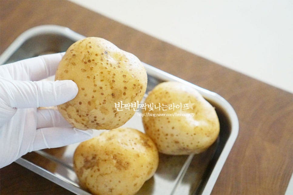 중간 크기의 감자 4개 정도를 준비했습니다. 포슬포슬 맛이 좋아서 전을 구워 먹으니 겉은 바삭하고 속은 쫀득하니 맛나요. 흙을 씻어낸 뒤 강판에 갈기 위해 껍질을 깎아줍니다. 혹시 싹이 있다면 독성이 있는 부분이라 익혀서 먹어도 탈이 날 수 있으니 도려내어주세요. 강판에 가는 동안 갈변이 되지 않도록 물에 담가둡니다.