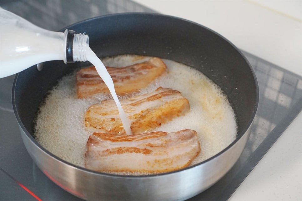 모든 면이 골고루 구워지면 막걸리를 부어줍니다. 자작한 정도로 잠기게 부어주는데요. 한 병~한 병반 정도면 됩니다. 끓어오르면 진간장 1 큰 술, 굴소스 1 큰 술 넣어주어요. 막걸리가 잡내를 잡아주며 달큰하기 때문에 약간의 양념재료를 넣어주면 간이 스며들어 더욱 맛있게 삶을 수 있어요. 양념을 섞어준 뒤 중불로 낮추어 30분 삶아줍니다. 명세빈 막걸리수육은 다른 레시피보다 간단한 게 야채나 다른 재료가 들어가지 않기 때문에 재료를 손질할 필요 없이 그대로 굽다가 삶아주면 된답니다. 중간중간 타거나 눌어붙지 않도록 돌려가며 골고루 삶아주어요. 뚜껑을 연 채로 졸이면서 삶아주면 알코올은 날아가고 양념이 스며들어 간도 배고, 더 쫀득한 느낌으로 수육을 만들 수 있어요. 30분 삶으니 딱 알맞게 익었습니다. 도마 위에 올려 한입에 먹기 좋게 썰어줍니다. 썰어보면 육즙이 가득하고 육향이 깊고 진해요.