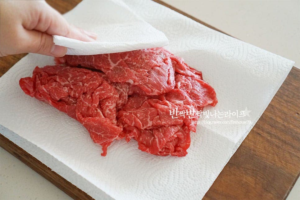 먼저 소불고기 양념에 재워줍니다. 키친타월로 핏물을 제거해요. 크기에 따라 한입에 먹기 좋게 잘라주어요. 배즙을 같이 넣어 부드러운 식감과 단맛 감칠맛을 더해주었어요. 배를 직접 갈아 만들었는데 시판용 배즙 사용하셔도 됩니다. 한약재가 들어가지 않은 배주스를 넣어주시고 당도에 따라 설탕량은 조절해 주세요. 배즙 70ml, 양파즙 2 큰 술 다진 대파 2 큰 술, 간 마늘 1 큰 술 간생강 약간, 간장 5 큰 술 맛술 3 큰 술, 황설탕 2 큰 술 매실액 1 큰 술, 후추 약간 넣어줍니다. 재료의 간을 보고 달달 면서도 짭조름하게 간을 가감하여 맞추어 주세요. 고기를 넣고 양념에 재워줍니다. 덩어리지지 않게 고기를 떼어내어 간이 고르게 스며들도록 해줍니다.