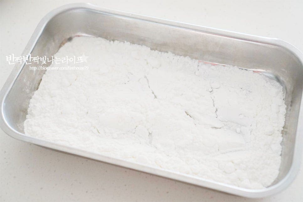 전분가루 1컵을 준비하여 넓은 트레이에 담아줍니다. 전분으로 튀겨서 바삭바삭하게 해줄 것이에요. 전체적으로 뭉치지 않게 골고루 전분옷이 입혀질 수 있도록 해줍니다. 전분 대신 튀김가루를 사용해도 됩니다. 전분을 묻혀 잠시 두면 튀김옷이 더 고르게 입혀져요.