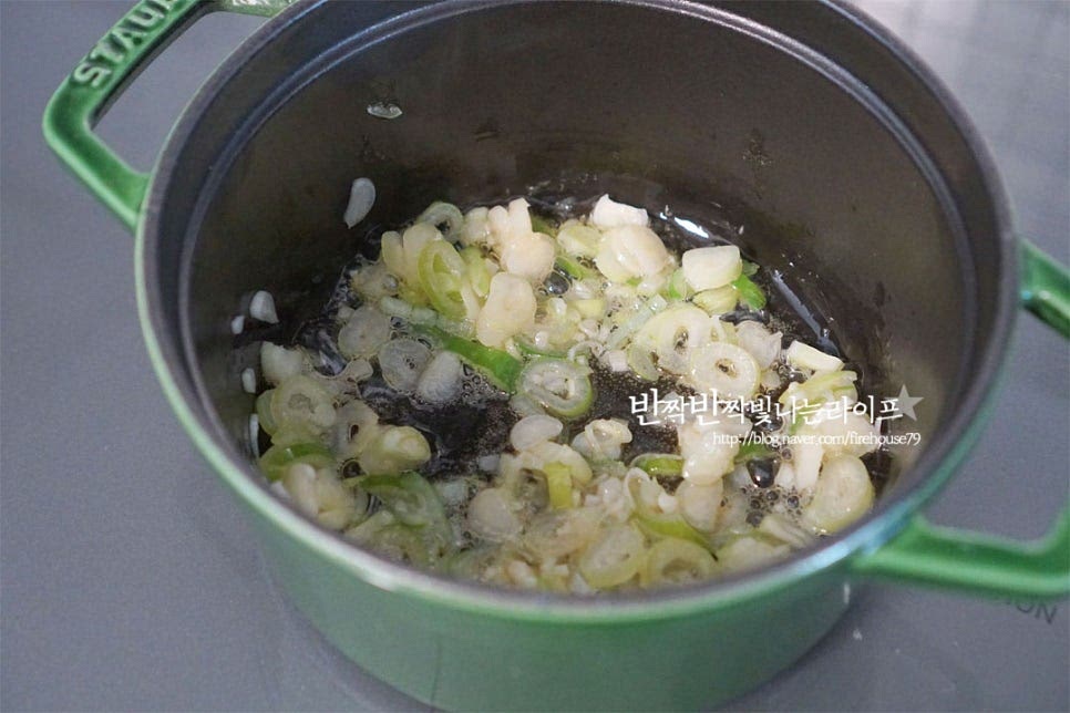 냄비에 식용유 2 큰 술, 참기름 1 큰 술을 넣고 대파를 먼저 볶아 파기름을 내어줍니다. 나른해지면서 달큰한 향이 올라오면 돼지고기를 넣어줍니다. 돼지고기가 볶아지면 양파도 넣어줍니다. 양파가 투명하게 익도록 충분하게 볶아준 뒤 간마늘 1 큰 술, 꽃소금 1/2 작은 술 넣어줍니다. 가볍게 섞어주고 고춧가루 두 가지 1½ 큰 술 황설탕 1 작은 술 넣어줍니다. 고운 입자와 굵은 것 두 가지를 섞어 넣어 매콤한 향미를 살려줍니다. 매콤하게 어우러지도록 볶아줍니다. 타지 않도록 불을 조절하여 약불에서 고추기름이 나오도록 볶아요, 고춧가루 날가루 냄새를 날리고 부드럽게 어우러지도록 볶은 뒤 국간장 1 큰 술을 테두리 부분으로 둘러 넣어요.