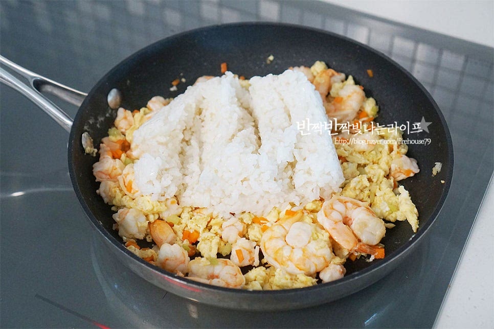 스크램블 에그가 섞이면 밥을 넣어줍니다. 고슬고슬하게 볶기 위해 뜨거운 밥보다는 즉석밥이나 찬밥을 넣어줍니다. 뭉치지 않고 풀어가며 볶아줍니다. 밥알이 풀어지면 한쪽으로 밀고 진간장 2/3 큰 술을 넣어줍니다. 지글지글 태우듯이 끓여 불향을 내어줍니다. 태운 간장의 풍미로 고소함을 더해줍니다. 굴소스 1/2~2/3 큰 술을 넣어줍니다. 굴소스가 들어가면 맛이 없을 수가 없죠. 짜지 않게 농도에 따라 양을 조절해 주세요. 골고루 섞이도록 볶아줍니다. 부족한 간은 소금으로 더하고 후추 약간 넣어줍니다. 참기름 1/2 큰 술을 넣고 마무리해요. 마지막에 고소한 참기름으로 중화풍 느낌을 내어줍니다.