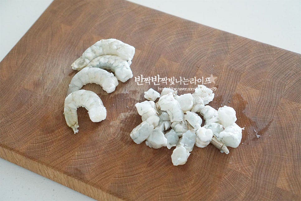 소분해두었던 새우살은 해동한 뒤 세척 후 물기를 제거해 줍니다. 크기가 큰 것이라 큼직하게 먹을 것 1/3분량은 그대로 넣고 나머지는 한입에 어우러지도록 잘라줍니다. 다른 재료를 손질하는 동안 맛술 1 작은 술을 뿌려 밑간해둡니다.