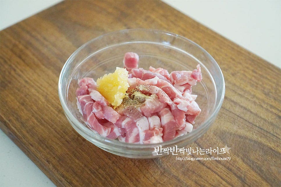 채 썬 돼지고기는 밑간해줍니다. 소고기로 대체 가능해요. 소금과 후추 약간, 간 마늘 1 작은 술 맛술 1/2 큰 술 넣고 가볍게 버무려줍니다. 전분가루 1 큰 술, 달걀흰자 1/3개를 넣고 조물조물 섞어 10분 정도 둡니다. 전분가루를 넣어주면 양념이 더 잘 스며들고 농도가 자연스럽게 맞추어진답니다.