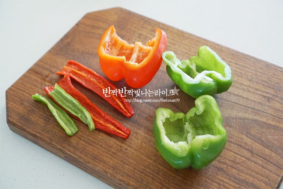 피망과 파프리카, 고추는 꼭지를 잘라내고 반으로 가른 뒤 가운데 씨 부분을 제거하여 손질해요. 매운맛을 좋아한다면 청양을 넣어주면 별미입니다. 매운채소는 손질할 때 장갑을 끼고 직접 닿지 않게 해주면 좋습니다. 먹기 좋게 채를 썰어주는데요. 피망은 세로로 썰기보다 둥근 모양을 살려 잘라주면 꼬불꼬불하여 식감도 아삭하고 맛나요. 양파는 채를 썰어주고, 대파 흰 부분은 잘게 썰어줍니다.