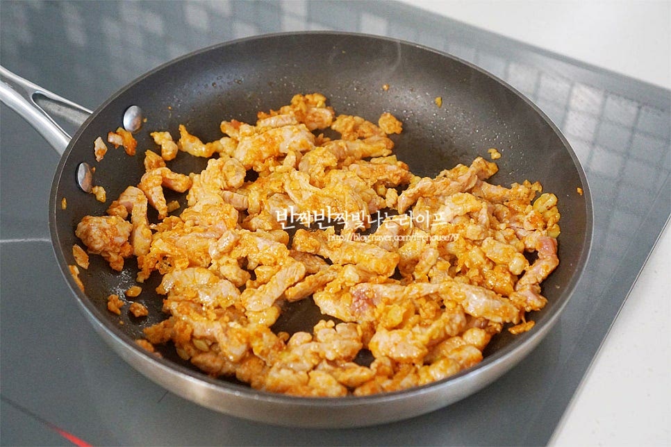 재워둔 고기를 넣고 볶아줍니다. 표면의 색이 변할 정도로 익혀주어요. 표면의 색이 변하면 양파를 넣고 볶아요. 2분 정도 볶아준 뒤 피망과 파프리카, 고추를 넣어줍니다. 아삭아삭한 식감과 색을 살리기 위해 지금부터는 센 불로 빠르게 익혀주어요. 가볍게 섞은 뒤 만들어둔 소스도 넣고 센 불에서 아삭아삭하게 볶아줍니다. 재료가 어우러지면 참기름을 넣고 마무리해요.