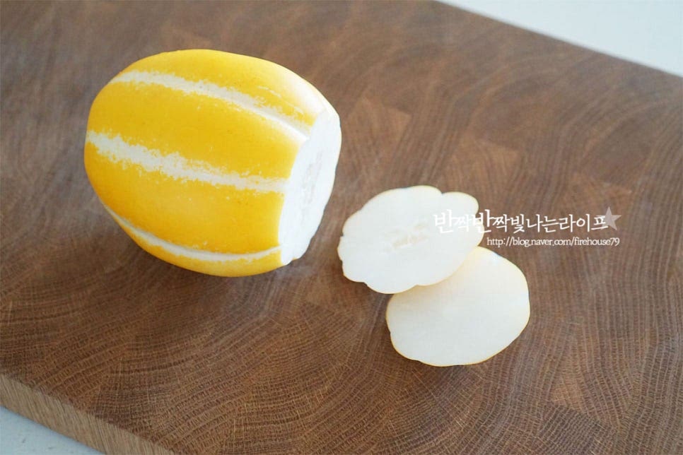세척 후 물기를 제거한 뒤 양 끝 부분은 잘라내어 줍니다. 껍질은 반 정도는 남겨두고 듬성듬성 제거해 줍니다. 중간중간 노란 껍질이 보이는 게 맛있어 보이는데요. 칼이나 필러로 모양을 내어주면 간편합니다. 반으로 나누어준 뒤 참외 씨 부분은 숟가락으로 씨와 속 부분을 긁어 따로 담아줍니다. 나중에 과즙을 따로 착즙해줄 것이에요. 참외 과육은 2~3mm 두께로 얇게 슬라이스해요. 얇게 썰어서 오독오독 식감이 느껴지며 샐러드 소스와도 잘 어우러집니다. 노란 껍질이 같이 보이니 맛있어 보이죠.
