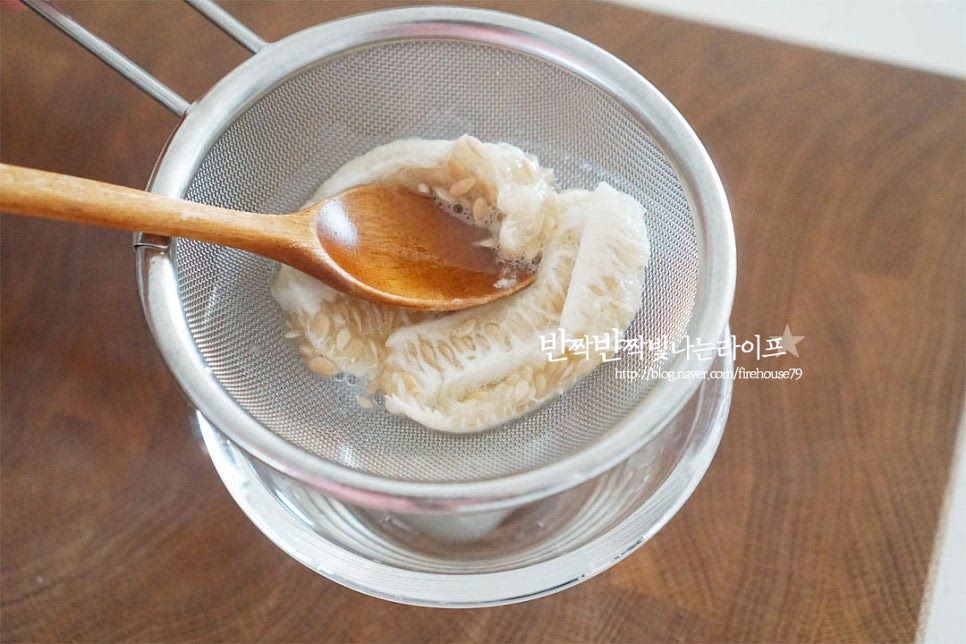 분리해둔 씨와 속 부분은 체에 밭쳐 숟가락으로 눌러 과즙을 짜줍니다. 드레싱에 넣으면 달콤한 단맛이 맛있어요.