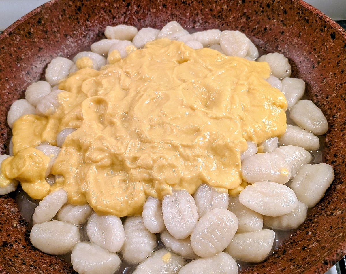 As the gnocchi start coming afloat, fish them out with a strainer or slotted spoon and transfer them to the pan with the spiced water. Once all the gnocchi are in the pan, add the Creamed Gorgonzola, leek and squash and raise the heat to medium.
