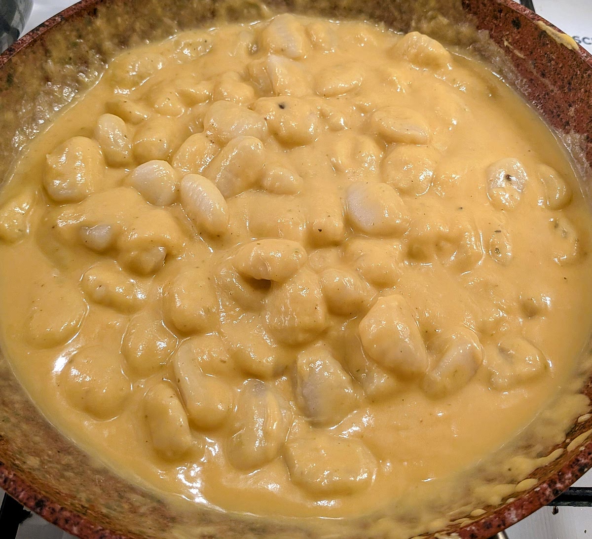 Toss it all together (or stir carefully with a spatula or wooden spoon) until the sauce has warmed up, coated all the gnocchi and slightly thickened (for about 2-3 minutes).