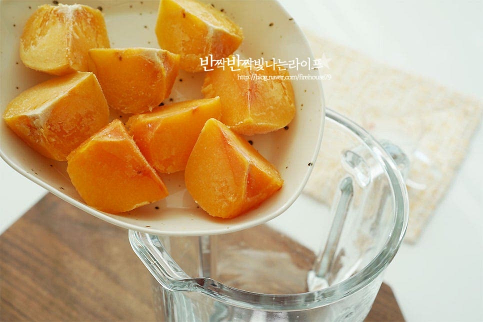 블렌더에 재료를 모두 넣어줍니다. 얼린 것이 아닌 걸로 만들 땐 과육만 발라내어 얼음과 같이 갈아주어요. 우유는 100ml 정도 넣어주었는데요. 갈리는 농도에 따라 가감해 줍니다. 플레인 요거트도 같이 넣어줍니다. 입맛에 따라서는 과육만 넣고 갈아도 되지만 요거트나 우유 같은 유제품이 들어가면 보다 부드럽게 맛볼 수 있어요. 과일 당도에 따라 꿀은 취향껏 넣어줍니다. 레몬즙 1/2 큰 술도 같이 넣어주었는데 신맛보다 재료의 감칠맛을 살려주는 역할을 해요. 없다면 생략 가능합니다. 재료를 모두 넣고 갈아주기만 하면 되어서 누구나 손쉽게 만들어 즐기기 좋은 요리랍니다. 부드럽게 갈아줍니다. 얼린 것은 잘 갈아지지 않을 수도 있는데 우유나 생수로 농도를 조절해 주심 좋아요. 홍시스무디는 마치 쉐이크 같은 느낌으로 맛있게 갈아지면 잔에 따라줍니다. 시원하면서도 달콤한 그 맛은 과일 그대로 먹는 것과 또 다른 부드러운 매력이 있어요. 스무디로 만들면 아이들 건강 간식으로도 좋고요~ 요리 영상을 같이 보시면 보다 쉽게 만들어 드실 수 있답니다. 달콤한 과일의 맛 그대로에 우유와 요거트, 꿀이 곁들여져 더욱 부드럽고 맛있게 즐길 수 있어요. 홍시스무디 만들기 제철에 냉동실에 소분하여 얼려둔 뒤 시원한 별미로 즐겨보세요. 달콤함 가득 이랍니다. 맛있게 만들어 드세요^^ 끄읕 !