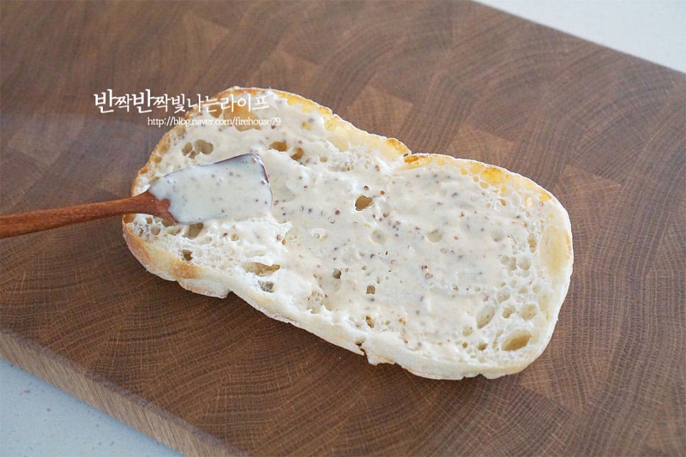 치아바타의 자른 단면에 소스를 고르게 발라줍니다. 그 위로 모차렐라치즈를 올려줍니다. 따뜻하게 그릴 팬에 구워줄 것이라 열을 가해 먹을 수 있는 모짜렐라를 준비했습니다. 햄을 넉넉하게 올린 뒤 토마토도 올려줍니다. 루콜라 반 줌도 풍성하게 넣어줍니다. 눌러서 구워 조리하기 때문에 적당하게 넉넉하게 넣어도 숨이 죽어 괜찮아요. 따뜻한 치즈가 늘어나는 맛이 별미라 치즈는 한 번 더 넉넉하게 올려줍니다. 그 위로 소스 바른 빵을 덮어줍니다.