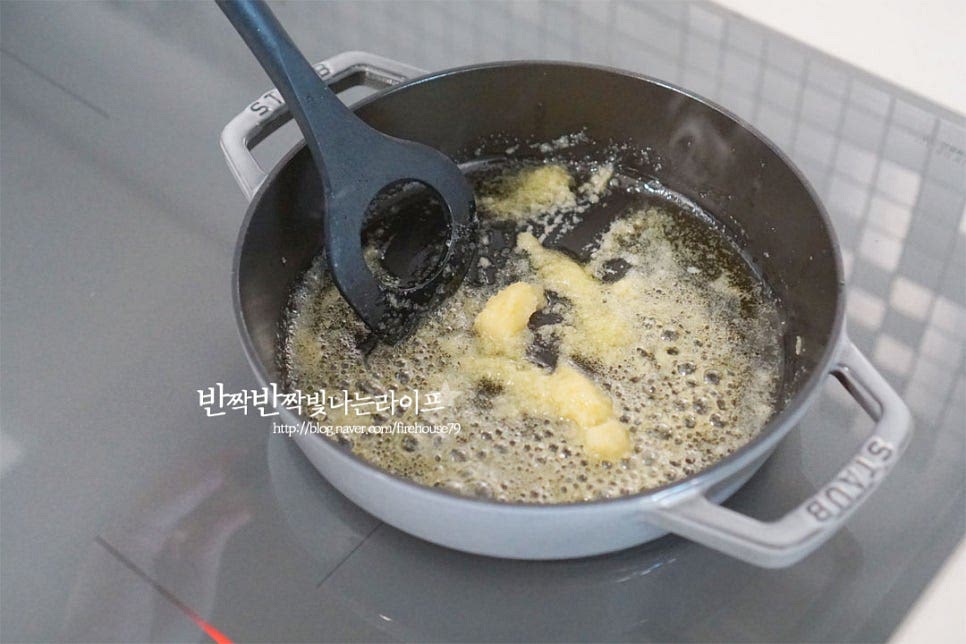 깊이가 있는 팬을 예열한 뒤 올리브오일 3 큰 술, 버터 10g 다진 마늘 1 큰 술을 넣고 볶아줍니다. 눌어붙거나 타지 않도록 중약 불로 조절하여 주세요. 마늘의 향이 올라오면 양파와 파프리카를 넣고 볶아줍니다. 양파가 투명빛이 나기 시작하면 불린 쌀을 넣어줍니다. 야채와 쌀이 어우러지도록 섞은 뒤 화이트와인 1 작은 술도 넣어줍니다. 알코올을 날리고 향미를 더해 볶아주어요.