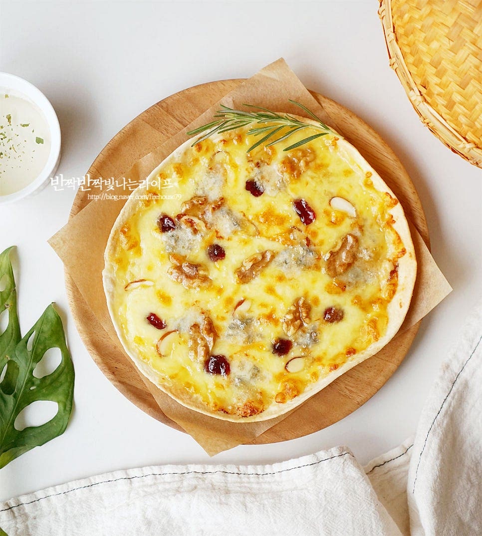 또띠아피자 만들기 완성입니다. 입맛에 따라 꿀이나 시럽을 곁들이면 짭조름한 치즈와 달콤한 꿀을 맛있게 맛볼 수 있습니다. 영상도 같이 담았어요. 녹진한 풍미를 진하게 맛볼 수 있는 피자는 치즈와 함께 어우러지는 허니 갈릭소스와 담백한 또띠아의 맛이 별미에요. 집에서도 간단한 레시피로 요리할 수 있고요. 소스를 바르고 토핑을 올려 구워내면 갓 구운 바삭함과 쫄깃한 식감, 깊고 풍부한 맛을 제대로 느낄 수 있어요. 집에서도 또띠아 고르곤졸라피자를 맛있게 요리해드세요. 끄읕 !