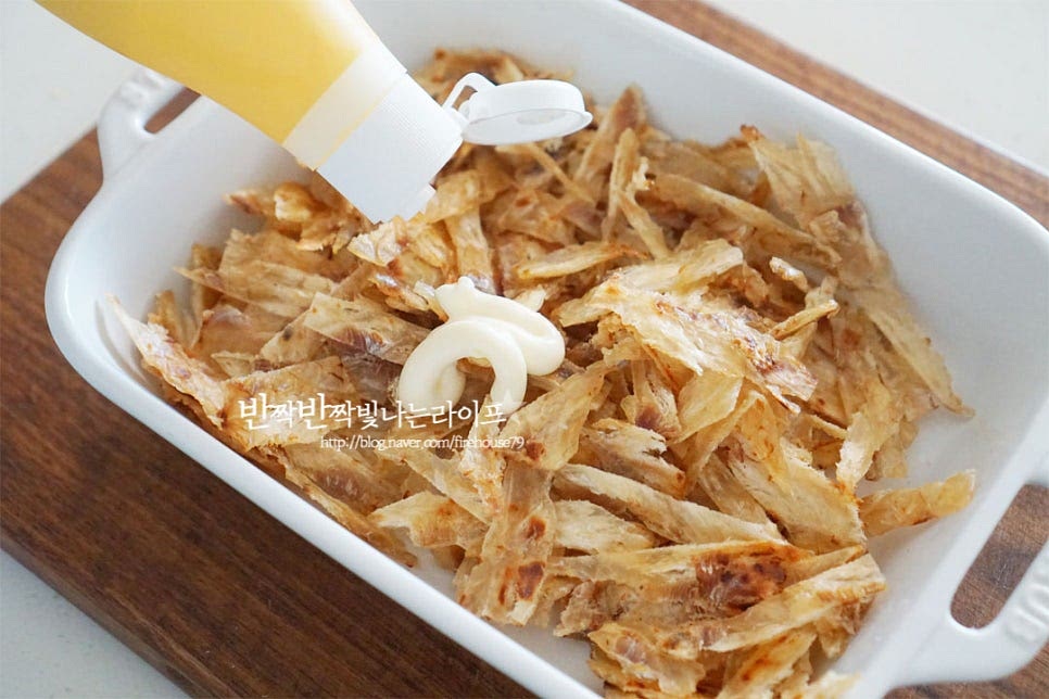 넓게 펼쳐 뜨거운 열기를 식힌 뒤 마요네즈 1큰술 듬뿍 넣고 버무려줍니다. 쥐포볶음이 딱딱하지 않게 마요네즈에 버무려주는데요. 고소한 풍미와 촉촉함이 유지되면서 양념 간도 더 잘 스며들어요. 골고루 버무려지도록 무쳐주었습니다. 이대로 먹어보아도 조미간이 되어 맛이 좋아요.