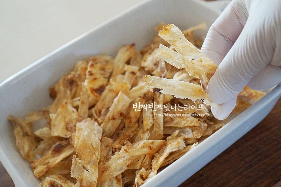 쥐포는 쥐치에 달콤 짭짤한 간을 해주었기 때문에 고소하게 구워서 바로 먹어도 맛이 좋은데요. 반찬으로 만들 때 집어먹기 좋도록 채를 썰어 만듭니다. 저는 구운쥐포채를 준비해 주었는데 동그란 모양이라면 길게 채를 썰어주면 됩니다. 냉장고에 넣어두었기 때문에 냉기로 인해 조금 눅눅할 수 있어 달군 마른 팬에 수분을 날려가며 볶아줍니다. 이 과정에서 눅눅함이 날아가고 고소해지며 비린 맛도 잡아줄 수 있어요. 겉이 바삭하고 노릇하게 구워지면 체에 넣고 살살 털어 잔가루를 정돈하여 줍니다. 그럼 더 깔끔한 맛을 낼 수 있어요.