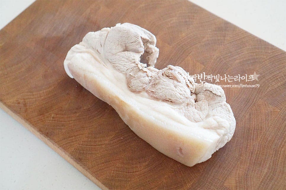 4시간 이상 냉장숙성해두었던 돼지앞다리살을 꺼내어 먹기 좋게 썰어줍니다. 따뜻하게 먹는 수육은 뜨거워야 맛있지만 냉수육은 차갑게 먹기 때문에 먹을 만큼 썰어먹고 다시 냉장고에 넣어둘 수 있어요. 얇게 썰어야 맛있기 때문에 두께를 얇게 썰어줍니다. 고기를 썰다 보면 핑크빛이 보이는데 저온에서 수비드 방식으로 익혀서 그런 것이라 속까지 잘 익은 것이니 안심해도 된다고 해요.