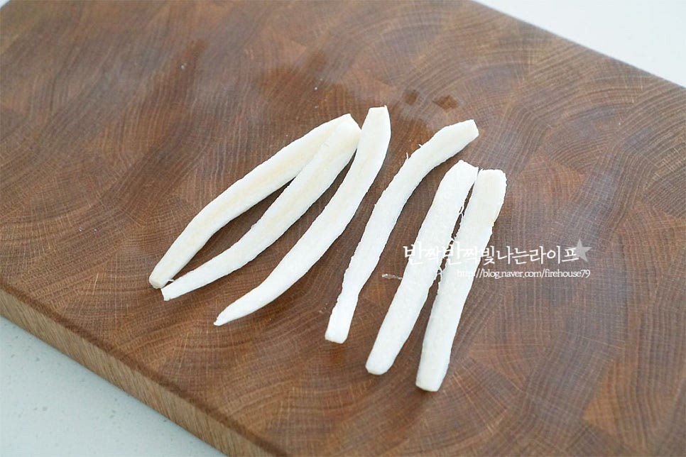 섬유질이 있기 때문에 먹기 좋게 결대로 찢어주는데요. 먼저 2등분으로 길게 잘라줍니다. 크기가 크지 않은 편이라 반으로 잘랐는데 두께에 따라 2~4등분 해 주셔도 좋습니다. 비닐팩에 너고 방망이로 자근자근 두드려줍니다. 너무 세게 힘을 주면 부서지기 쉬우니 결방향을 보아가며 두드려주면 됩니다. 끈적한 진액이 손에 묻어나서 장갑을 끼고 비닐팩 안에서 손질해 주었습니다. 결대로 질긴 섬유질을 부드럽게 해주는 과정입니다. 결대로 굵게 찢어줍니다. 칼이나 가위를 사용하지 않고 두드려 찢어주면 부드럽게 아삭한 식감도 좋고 양념도 더 맛있게 어우러집니다.