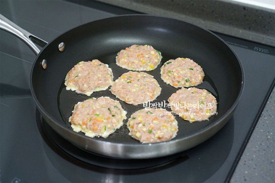 달군 팬에 식용유를 적당히 두르고 계란참치전을 동그란 모양으로 올려줍니다. 한입에 먹기 좋게 동그랗게 모양을 잡아주었어요. 모양과 크기는 취향껏입니다~ 먹음직스러움을 더해줄 홍고추도 올려서 중불로 앞뒤로 노릇노릇하게 구워줍니다. 맛있게 구워서 그릇에 담아줍니다. 동글동글 하나씩 집어먹는 맛이 있죠. 얼핏 보면 동그랑땡 같지만 먹어보면 또 다른 매력이 있어요. 요리 영상을 같이 보시면 만드시는 데 도움이 되실 거예요. 누구나 맛있게 맛볼 수 있는 반찬이며 바쁜 아침 손쉽게 만들기 좋은 참치캔요리 랍니다. 계란과 야채를 같이 넣어 만들면 영양도 더해줄 수 있고요. 참치전 맛있게 구워서 도시락반찬으로 어떠세요. 만드는법 어렵지 않고 자투리 채소를 활용하여 맛도 살리고 특유의 감칠맛을 담아 고소하고 맛깔나게 즐길 수 있답니다. 맛있게 만들어 드세요^^ 끄읕 !