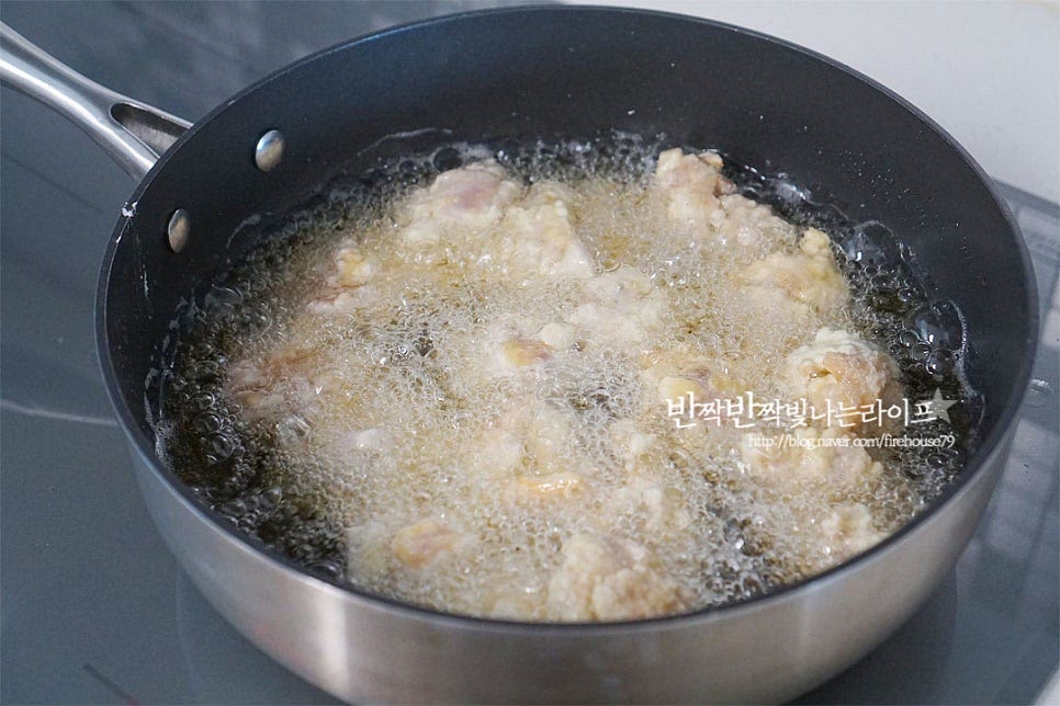 달군 팬에 식용유를 넉넉히 넣고 170도 정도 온도가 되면 닭고기를 넣고 튀겨줍니다. 반죽이 서로 붙지 않게 젓가락으로 저어가며 튀겨줍니다. 첫 번째 튀겨준 뒤 채망에 옮겨 담아요. 기름을 한번 정리해 준 뒤 한 번 더 튀겨줍니다. 두 번 튀겨주어 바삭한 식감을 살려주었어요. 두 번째 튀기면 색감이 더 노릇해져요. 그리고 만들었을 때 바삭함이 더 오래간답니다~ 먹기 좋게 익으면 건져내어 튀김 망에 올려 기름을 빼줍니다. 공기가 통하도록 튀김 망에 올려주시면 식감을 더 살려줄 수 있어요.