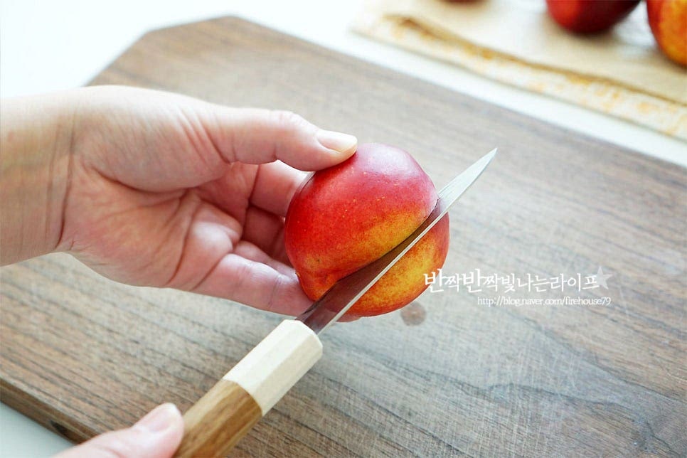 과육을 잘게 썰어줍니다. 복숭아 자르는법 알아두면 보다 손쉽게 손질할 수 있어요. 먼저 껍질에 보이는 파인 부분을 따라 칼집을 넣어주는데요. 칼날이 씨에 닿도록 칼집을 넣어줍니다. 열십자 모양으로 한 번 더 칼집을 넣어줍니다. 양손으로 위아래를 잡은 뒤 살짝 비틀어주면 과육이 분리되어요. 씨를 중심으로 과육이 분리되었어요. 이렇게 잘라주면 씨와 깔끔하게 분리할 수 있어요. 과육은 작은 크기로 잘게 썰어줍니다. 작은 크기로 썰면 식감도 좋아요.