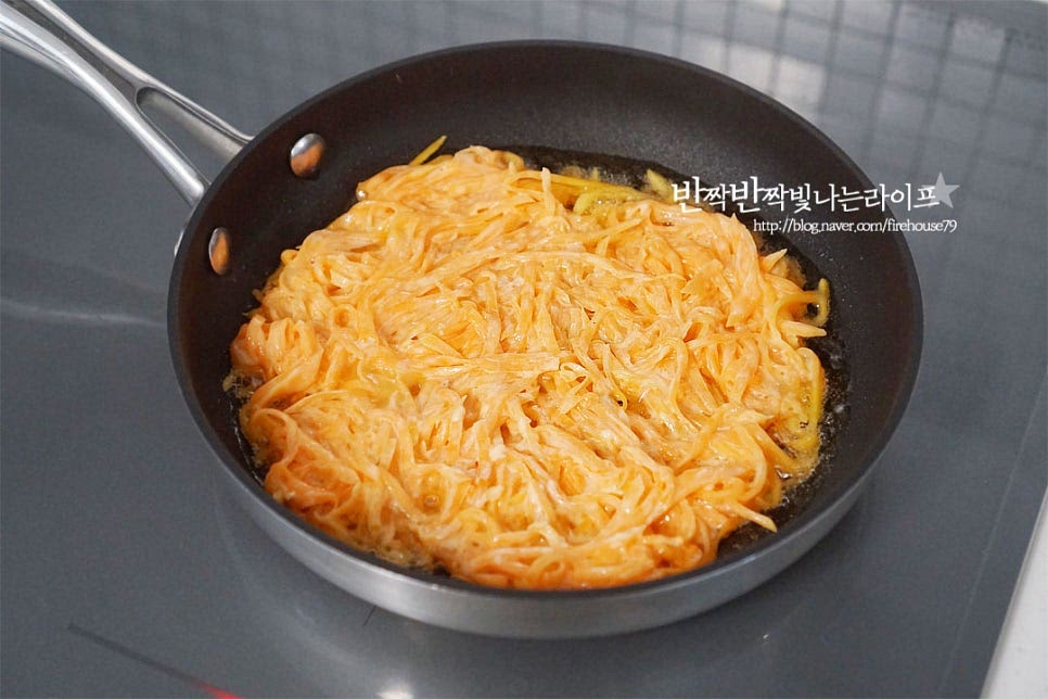 달군 팬에 식용유 넉넉하게 두른 다음 적당량의 반죽을 동글 납작하게 펼쳐 올립니다. 너무 두껍지 않게 올려 겉바속쫀의 식감을 살려 굽습니다. 부침개를 부칠 때는 지글지글 소리가 나도록 식용유를 둘러줘야 고소한 풍미는 물론 전체적으로 노릇하고 고르게 부쳐집니다. 모양을 잡아가며 중불로 낮추어 타지 않도록 속까지 잘 익을 수 있도록 구워줍니다. 한쪽 면이 익어 색이 변하면 뒤집어 앞뒤로 노릇노릇 구워줍니다. 익힘 정도에 따라 불을 조절해 구워 완성합니다. 테두리 부분은 바삭하면서 속은 쫀득하게 익습니다.