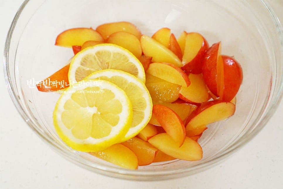 큼직한 크기의 볼에 자른 자두와 레몬 1/2개를 슬라이스해서 넣어줍니다. 레몬은 씨가 들어가면 쓴맛이 나므로 씨를 제거한 뒤 넣어주면 됩니다. 레몬은 레몬즙 2~3 큰 술로 대체 가능하며 같이 넣으면 새콤달콤한 풍미는 물론 색도 예쁘게 만들어져서 맛있어요. 과육과 같은 비율로 설탕을 넣어줍니다. 기본 1:1 비율로 만들면 보관 기간 저장성이 좋은데 단맛을 줄이고 싶다면 1:0.8 정도로 줄여도 좋습니다. 많은 양을 만든다면 동일 비율로 만드는 게 좋아요. 재료가 어우러지도록 버무려서 실온에서 설탕이 녹을 수 있도록 둡니다. 수분이 많은 과일이라 생각보다 잘 녹습니다.