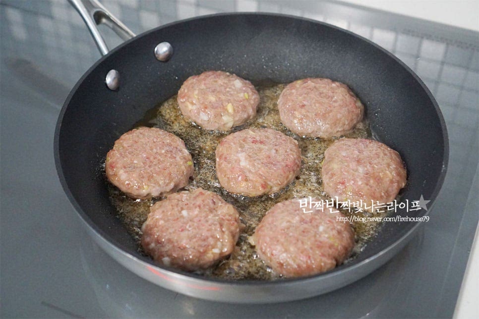 달군 팬에 식용유를 약간 두른 뒤 만든 반죽을 하나씩 겹치지 않게 올려줍니다. 양념이 된 것이라 센 불에서는 겉만 타기 쉬우니 속까지 익을 수 있도록 중약 불로 조절하여 구워줍니다. 또 너무 약불에서도 핏물이 새어날 수 있어요. 한쪽 면이 노릇하게 구워지면 뒤집어 앞뒤로 굽습니다. 테두리부터 익기 때문에 뒤집으면서 가운데 부분을 숟가락으로 살짝 눌러 고정해 주고 구웠습니다. 절반 이상 익고 도톰하게 부풀면 만들어둔 조림장을 발라 윤기나고 먹음직스럽게 구워줍니다. 겉은 윤기가 반짝이고 속은 촉촉하게 익으면 완성입니다.