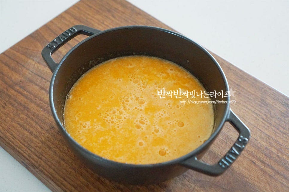 냄비에 간 귤을 넣어줍니다. 귤로 만드는 잼 같은 경우 과일 자체의 당도가 높은 편이라 설탕량은 과육의 30~50% 정도 넣어주시면 되어요. 손질한 과육 700g, 설탕 350g 넣어주었습니다. 수일 내 드실 것은 30% 정도 조금 더 두고 드시고 싶다면 50% 정도 넣어주세요. 그대로 불 위에 올려 끓여줍니다. 바글바글 끓어오르면 중약 불로 낮추어 뭉근하게 끓여줍니다. 끓어오른 뒤 중약불에서 5분 정도 끓이다가 레몬즙 1 큰 술 넣어줍니다. 잼 만들기 할 때 레몬즙을 넣어주시면 보관 기간도 길어지고 색감도 좋아요. 한 번씩 저어가며 끓여줍니다. 20~30분 정도 끓이다 보면 농도가 점점 걸쭉하고 짙어져요. 농도를 확인하기 위해 그릇에 찬물을 담고 약간 떨어뜨려 봅니다. 떨어뜨려보았을 때 퍼지지 않고 가운데로 뭉쳐 떨어지면 적당하게 잘 끓여진 것이에요. 보기에는 잼의 질감보다 묽은 것 같아 보여도 식으면 더 걸쭉하게 굳으니 농도를 잘 맞추어주셔야 크리미한 질감을 살려 드실 수 있습니다.