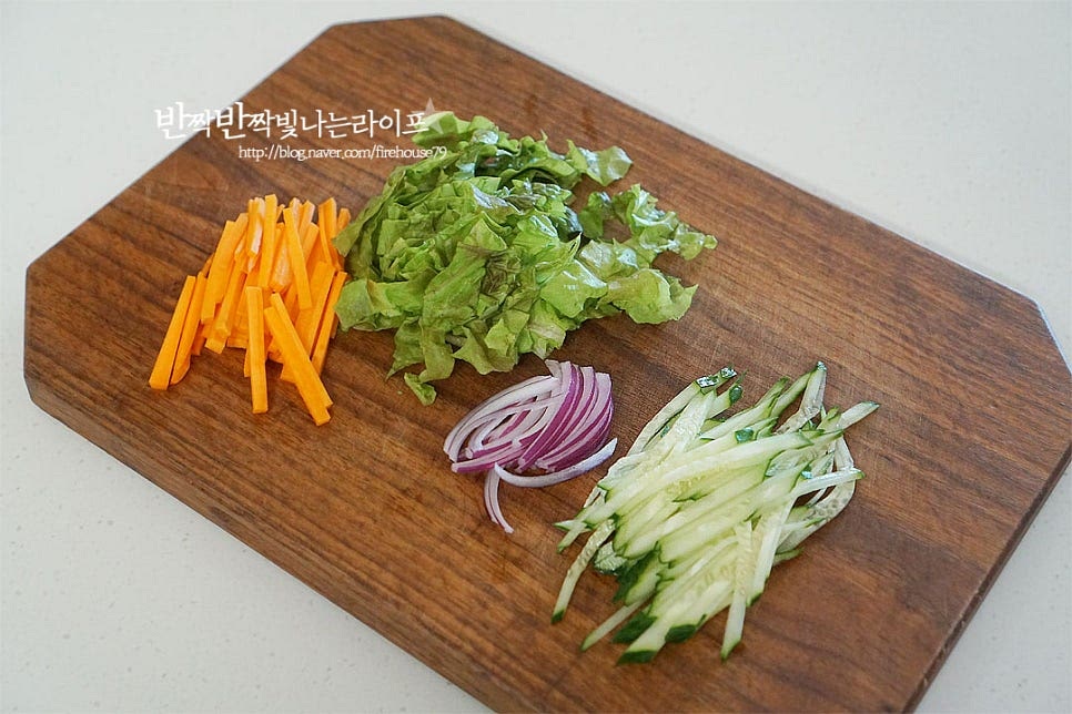 고명으로 곁들여줄 부재료 야채를 곤약면과 어우러지도록 채 썰어줍니다. 당근과 오이는 어슷하게 썰어 곱게 채를 썰고, 양파와 상추도 크기 밸런스를 맞추어 잘라줍니다. 앞서 말씀드린 것과 같이 채소는 여러 가지 넣어주면 푸짐하고 맛나요. 곤약분말로 만들어진 곤약면은 쫄깃하고 탱글 한 식감이 맛이 좋은데요. 오늘은 단호박이 들어간 노란색 면으로 요리했어요. 밀가루로 만든 면과 달리 불지 않고 꼬들꼬들 탱탱해서 여름철 시원하게 먹기 좋아요. 시판용이 잘 나오기는 하지만 특유의 냄새를 잡아주기 위해 끓는 물에 식초 1 작은 술 넣고 30초 정도 데친 뒤 찬물에 헹구어 물기를 털어줍니다.