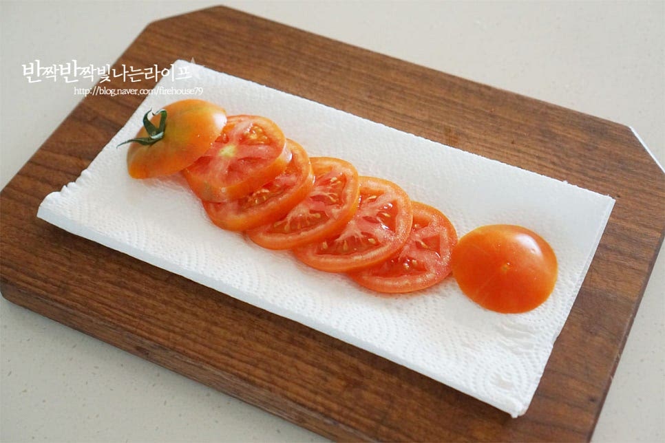 토마토는 크기에 따라 1/2~2/3개 준비한 뒤 0.5~0.7cm로 슬라이스해줍니다. 자른 뒤 키친타월에 올려 수분을 정돈해 주어요. 키친타월에 겉의 수분을 제거해 주셔야 샌드위치를 만들었을 때 물이 생기지 않아요. 달군 팬에 식용유를 두르고 계란을 구워줍니다. 이때 완숙 또는 반숙으로 기호에 맞게 구워요. 저는 반숙과 완숙 사이로 구웠어요. 샌드위치 빵 크기에 맞도록 구워주시면 좋습니다. 베이컨은 길이가 길어 반으로 자른 뒤 앞뒤로 노릇노릇하게 구워줍니다. 1개를 만드는데 1½ 줄 넣어주었어요. 팬을 정돈한 뒤 버터를 녹여 식빵을 노릇하고 고소하게 구워줍니다. 버터에 구워 만들면 식감도 풍미도 좋아요.